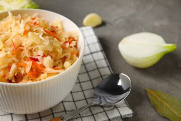 Delicious sauerkraut with ingredients on table
