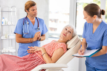 Obraz premium Physician listening to her patient during consultation while patient on couch in office of modern medical center.