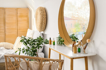 Dressing table with cosmetic products in interior of light bedroom