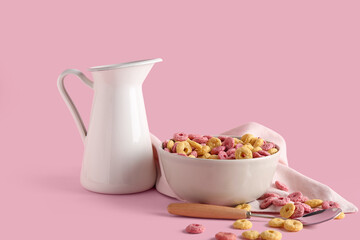 Bowl with color cereal rings on pink background