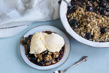 Homemade cherry crisp served with French vanilla ice cream. Table top view. Flatlay.