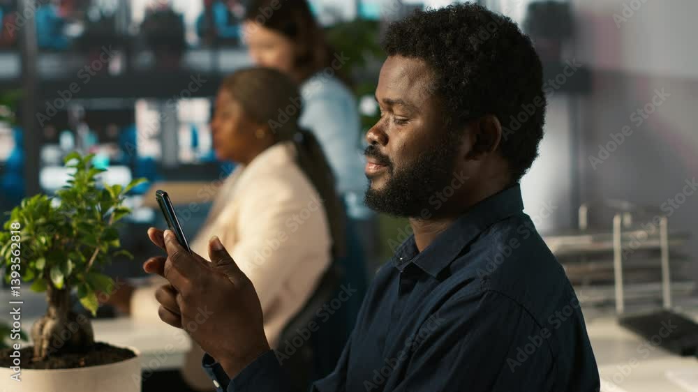Poster employee in office taking break from checking documents to text friends using smartphone, relaxing. 