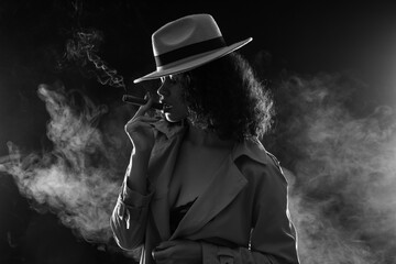 Sexy African-American woman smoking cigar on dark background © Pixel-Shot