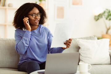 Business, Technology And Communication Concept. Busy black woman in specs making phone call while...