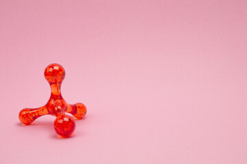 Hand massager on a light pink surface, side view, perfect for self-care messaging and relaxation...