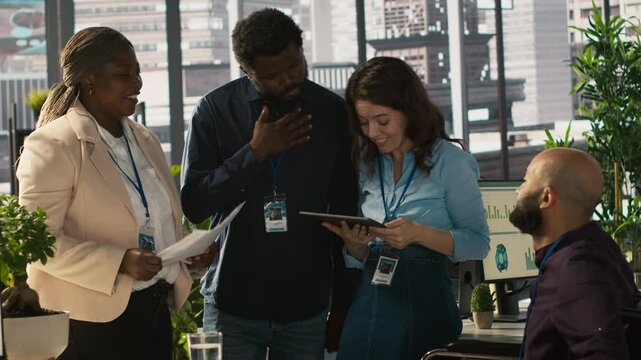 Employees and coworker with disability looking over revenue figures in inclusive office. Man in wheelchair working together with colleagues, comparing company statistical numbers, camera A