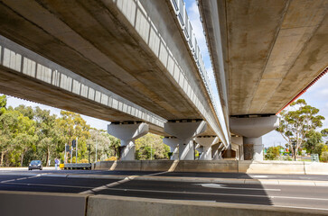 An elevated railway overpass and the roadway of multiple lanes beneath it. Concepts of civil...