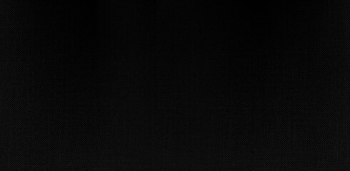Panoramic close-up texture of natural weave cloth in dark and black color. Fabric texture of natural cotton or linen textile material. Black fabric wide background.
