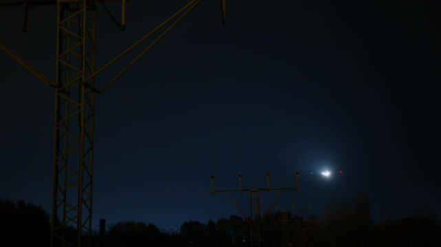 Nighttime airplane landing approach with illuminated runway, approach lighting system guiding aircraft closer to touchdown at airport
