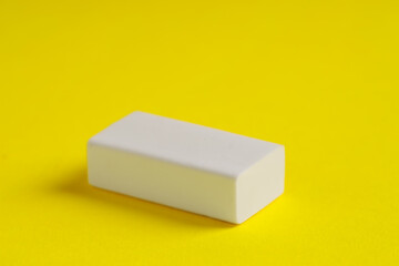 One eraser on yellow background, closeup view