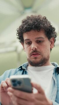 Vertical video, Close-up, man looks at google map on mobile phone and looks around on modern city background
