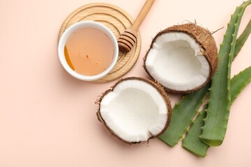 Hair treatment. Fresh coconut, honey and aloe leaves on beige background, flat lay. Space for text