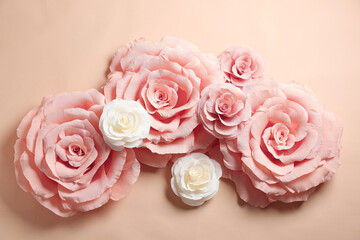 Beautiful paper flowers on beige background, flat lay