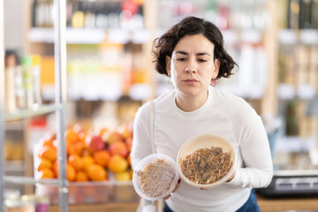 In store, woman near counter looking at yakisoba. Visitors make choice of assortment, select buy oriental food made from noodles, meat and spicy sauce.