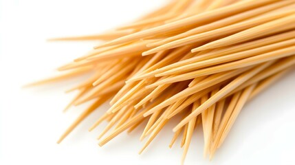 Closeup Pile of Pointed Wooden Toothpicks on a Clean White Background Surface