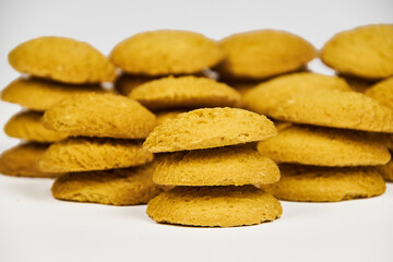 A group of sugar cookies are neatly stacked on top of each other on a white background..Close-up