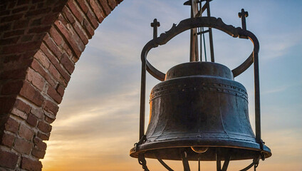 Silhouette of a church bell tower at sunset.