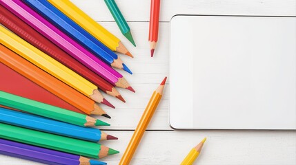 Naklejka premium Colorful pencils and blank notepad on white surface