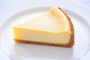 Simple Cheesecake Slice with Graham Crust on White Surface