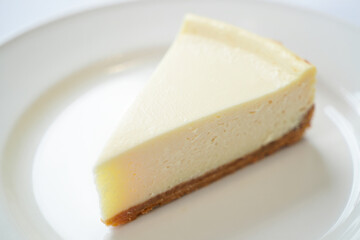 Single Slice of Smooth Cheesecake on Bright White Plate