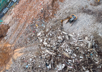 Large tracked excavator with hydraulic hammer breaks asphalt at a construction site