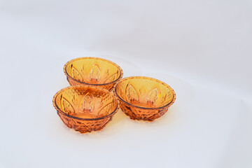 Elegant amber glass bowls showcase delicate floral patterns on white background