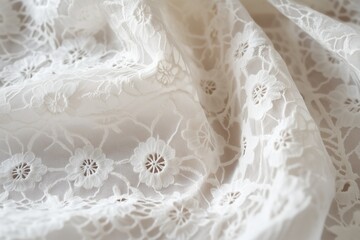 Close-up of delicate white Broderie Anglaise lace fabric with floral patterns and intricate details, showcasing the texture and design of the material.