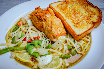 Italian tasty pasta with seafood and vegetables served in a white plate with a side of toast bread.