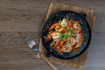 Fried shrimp with garlic and pepper on black plate - seafood style