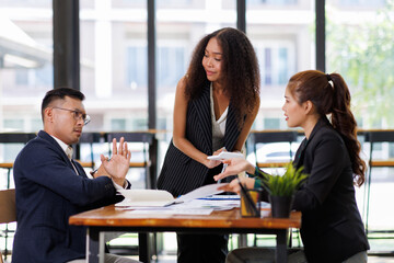 Team of confident business people point to graphs and charts to analyze market data, balance sheet, account, net profit to plan new sales strategies to increase production capacity.	

