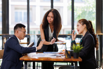 Team of confident business people point to graphs and charts to analyze market data, balance sheet, account, net profit to plan new sales strategies to increase production capacity.	
