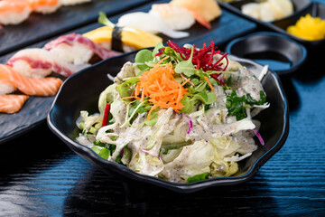 Fresh vegetable salad and sushi
