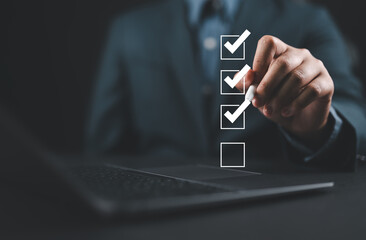 Businessman use pen to tick correct sign mark in checkbox for quality document control checklist...