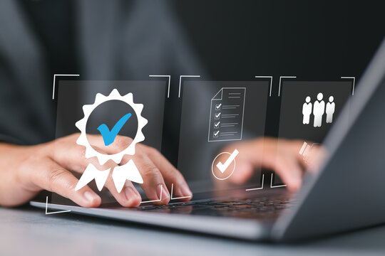Businessman using laptop with quality assurance and document icon for ISO or International Standard Organization which related quality control and continuous improvement concept.