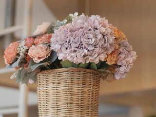 bouquet of pink roses. Beautiful bunch of artificial flower in wooden basket. Famous decoration interior design in restaurant.