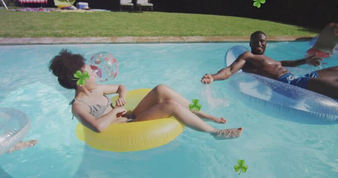 People relaxing on pool floats with clover animations in sunny backyard pool
