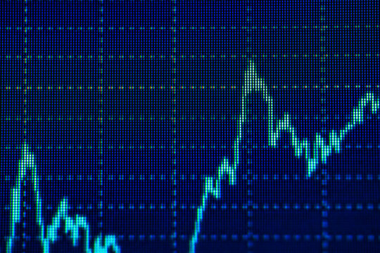 Blue graph display showing fluctuating financial data trends on digital screen