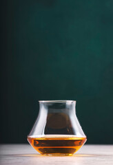 American rye whiskey in glass on dark green background