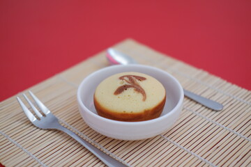 a single round sponge cake served in a white bowl