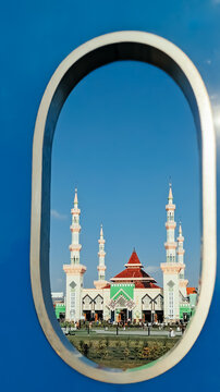 Frame in frame view. A majestic mosque architecture building in the city square exposed against the morning sunlight viewed through the hole