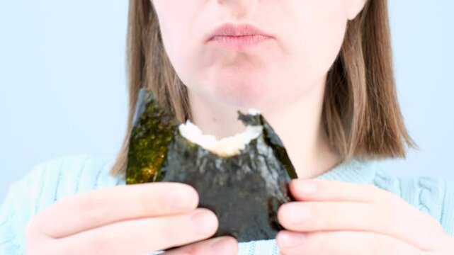 Young woman holding korean samgak close-up on gray background.