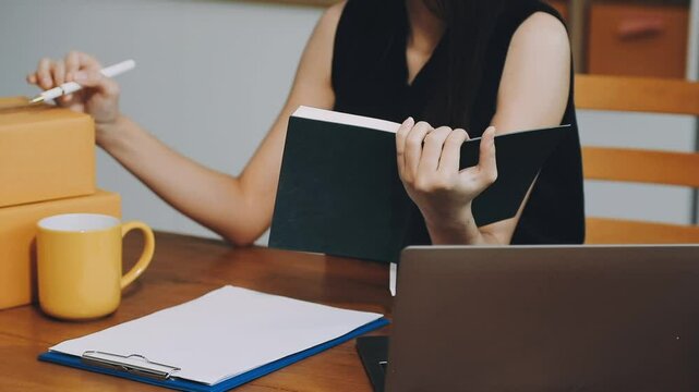 Business woman start up small business entrepreneur SME success .freelance woman working at home with Online Parcel delivery. SME and packaging deliveryconcept