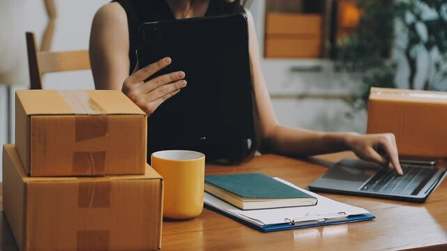 Business woman start up small business entrepreneur SME success .freelance woman working at home with Online Parcel delivery. SME and packaging deliveryconcept