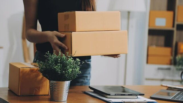 Business woman start up small business entrepreneur SME success .freelance woman working at home with Online Parcel delivery. SME and packaging deliveryconcept