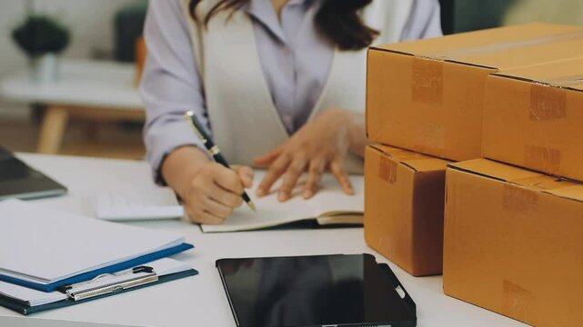 Business woman start up small business entrepreneur SME success .freelance woman working at home with Online Parcel delivery. SME and packaging deliveryconcept