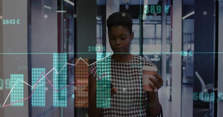 Businesswoman holding coffee with financial data animation overlay in office hallway