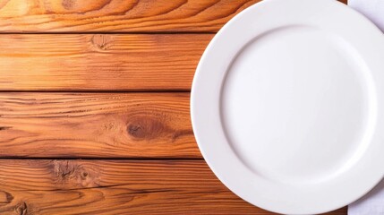 A simple ceramic plate sits on a rustic wooden table, showcasing the warm tones and textures of the wood alongside a cloth napkin