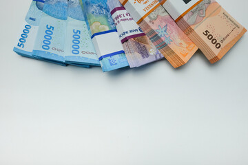 Stacks of Indonesian Rupiah Banknotes in Various Denominations on White Background