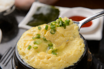 A spoonful of Korean style custarded eggs is lifted
