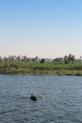 Landscape along the Nile River with fishermen in their rowing boat in the morning, Egypt
